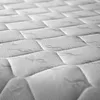 A close-up, angled view of a quilted mattress surface. Produktbild-Vorschau