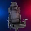 A black gaming chair is shown against a gradient background of blue and red. Produktbild-Vorschau