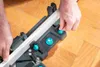 Hands adjusting a miter box with a piece of trim inserted. Produktbild-Vorschau