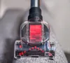 A close-up view of a vacuum cleaner head with a transparent casing showing red components inside and bristles at the bottom. Náhľad obrázku produktu