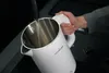 A person is pouring water into a white electric kettle. Produktbild-Vorschau