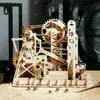 A wooden marble run model with marbles on a sandy surface. Voir les images du produit