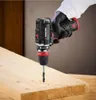 A hand wearing a glove is holding a cordless drill and drilling into a wooden plank. Produktbild-Vorschau