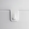 A white hook attached to a white surface. Produktbild-Vorschau