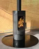 A black freestanding wood-burning stove with flames visible inside, placed on a circular glass hearth plate in front of a wooden panel background. Náhľad obrázku produktu