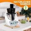 A kitchen appliance, likely a food processor or blender, is shown on a countertop with a bowl of salad and a glass of juice nearby. The appliance is placed on a wooden board. Voir les images du produit