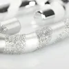 Close-up of a silver and white striped candy cane ornament with glitter. Produktbild-Vorschau
