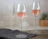 Two wine glasses filled with rosé wine on a wooden table with a dark gray cloth. Podgląd zdjęcia produktu