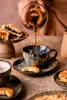Coffee being poured into a cup with pastries and cookies on a table. Podgląd zdjęcia produktu