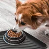 A dog eating from a food bowl placed on a black plastic tray. Voir les images du produit