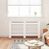 A white radiator cover is placed in front of a window with blinds. Podgląd zdjęcia produktu