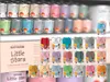 A display of Rust Oleum Little Stars paint cans in various colors, arranged on shelves and in a promotional display. Produktbild-Vorschau