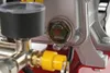 A close-up view of an air compressor's oil level indicator and some fittings. Náhľad obrázku produktu