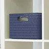 A blue woven storage basket sits on a white shelf. Voir les images du produit
