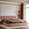 A pink upholstered bed with pillows and a throw blanket, set in a bedroom with a large window and curtains. Anteprima dell’immagine prodotto