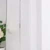 A close-up view of a sheer curtain with a floral arrangement to the left. Produktbild-Vorschau