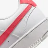 A close-up view of the side of a white Nike sneaker with a coral swoosh. Produktbild-Vorschau