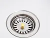 A close-up shot of a stainless steel sink drain with a gold stopper. Náhľad obrázku produktu
