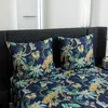 A close-up view of a bed with a duvet cover and pillows featuring a jungle print with leopards and palm trees. Náhľad obrázku produktu
