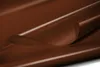 A close-up, abstract shot of a brown, glossy material, likely a tarp or fabric, with soft lighting and smooth curves. Produktbild-Vorschau