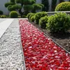 Roter Glas-Splitt 3–5 cm im Gartenbeet neben weißem Kiesel Produktbild-Vorschau