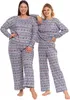 Two women are posing in matching Christmas-themed pajamas. Produktbild-Vorschau