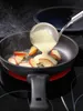 A ladle pouring batter into a frying pan with apple slices, on a stovetop. Náhľad obrázku produktu