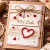 Selbstgebastelte Grußkarte mit rotem Holzherz und Schriftzug „Mit Liebe“ im Vintage-Stil. Podgląd zdjęcia produktu