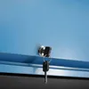 A close-up view of a lock and key on a blue cabinet. Produktbild-Vorschau
