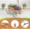 A wooden wagon planter filled with flowers sits on a patio, with additional plants and a house in the background. Below are close-up shots highlighting product features. Voir les images du produit
