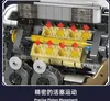 A close-up view of a detailed model engine, likely a toy or building set, with red arrows indicating the movement of pistons. Voir les images du produit
