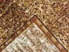 A close-up view of a rug with a speckled pattern and a border. Náhled obrázku produktu