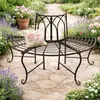A curved metal bench in a garden setting with flowers and a stone pathway. Náhled obrázku produktu