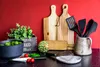 A kitchen counter with various cooking utensils and vegetables. Produktbild-Vorschau