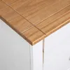 A close-up view of the corner of a white sideboard with a wooden top. Náhled obrázku produktu