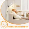 A woman is sleeping on a couch next to a floor lamp. Náhľad obrázku produktu