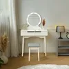 A white vanity table with a lighted mirror and a gray stool in a room with light gray walls and a wooden floor. Náhled obrázku produktu