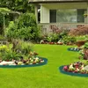 A landscaped garden with a house in the background, featuring green lawn and flower beds bordered by green edging. Voir les images du produit