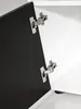 Close-up of cabinet hinges on an open black cabinet door. Produktbild-Vorschau