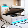 A white upholstered bed with storage, the mattress is lifted to reveal storage space underneath. The bed has LED lighting along the base. Náhľad obrázku produktu