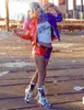 A woman dressed as Harley Quinn poses with a baseball bat. Produktbild-Vorschau
