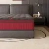 A close-up view of a mattress on a bed frame, with a nightstand and decor in the background. Voir les images du produit