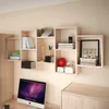 A modern home office setup with a wall-mounted bookshelf filled with books and decorative items, and a computer on a desk. Voir les images du produit
