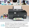 A printer with ink bottles in front of it, with people in the background. Podgląd zdjęcia produktu