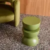 A green side table is placed next to a green armchair on a speckled floor. Produktbild-Vorschau