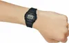 A person's arm wearing a black digital watch. Produktbild-Vorschau