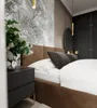 A bedroom scene with a bed, nightstand, and wardrobe. Podgląd zdjęcia produktu