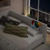 A daybed with pillows and a tablet charging on the side, with a city view at night through the window. Náhled obrázku produktu