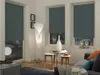 A living room scene with roller blinds on the windows, a floor lamp, and a sofa. Produktbild-Vorschau