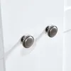 A close-up view of two cabinet knobs on a white surface. Produktbild-Vorschau